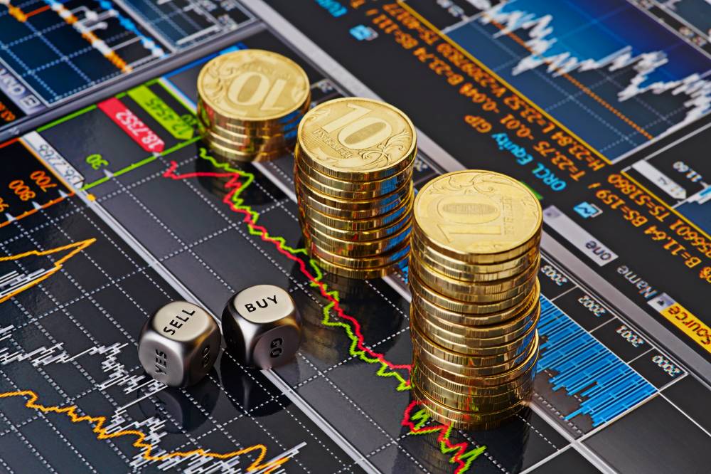 Dices cubes with the words SELL BUY, Uptrend stacks of golden coins. Financial chart as background. Selective focus